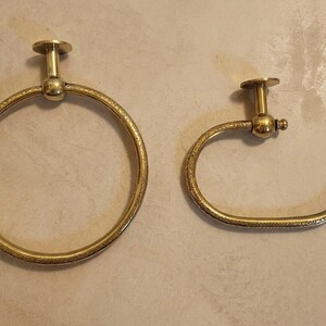 Close-up of unlacquered brass bathroom hardware showing authentic Moroccan craftsmanship and a sleek minimalist round design