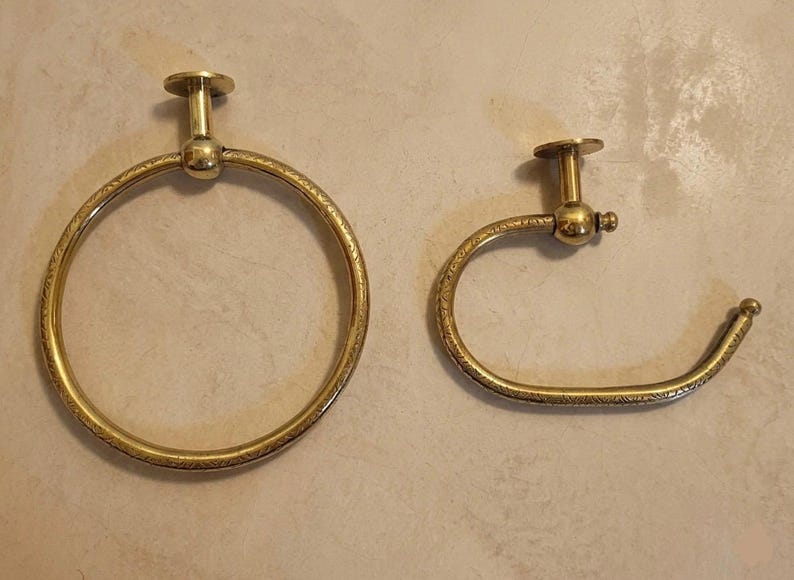 Close-up of unlacquered brass bathroom hardware showing authentic Moroccan craftsmanship and a sleek minimalist round design