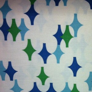 May include: A white fabric with a repeating pattern of blue and green diamond shapes.