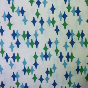 May include: White fabric with a repeating pattern of blue and green diamond shapes.