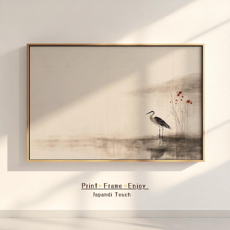 Framed Japandi-style artwork depicting a graceful heron by still waters, with subtle red flowers providing a gentle contrast. The sumi-e–inspired ink technique and earthy tones embody Wabi Sabi elegance. Hanging on a light-toned wall, the piece brings calm and balance to any minimalist or zen-inspired interior.