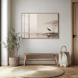 A Japandi-inspired art print of a heron and soft red flowers hangs above a bench in a minimalist entry room. The ink-wash texture, muted colors, and graceful composition create a serene focal point, bridging Japanese aesthetics with Scandinavian calm. A perfect balance of stillness and visual harmony.