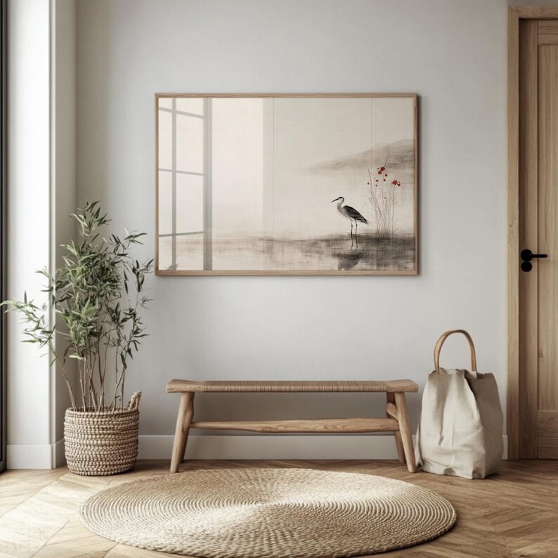 A Japandi-inspired art print of a heron and soft red flowers hangs above a bench in a minimalist entry room. The ink-wash texture, muted colors, and graceful composition create a serene focal point, bridging Japanese aesthetics with Scandinavian calm. A perfect balance of stillness and visual harmony.