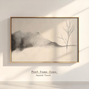 Puede incluir: Una impresión de arte minimalista en blanco y negro de una cordillera con un solo árbol en primer plano. La impresión está enmarcada en un marco de madera claro y tiene el texto "Print Frame Enjoy Japandí Touch" debajo de la imagen.