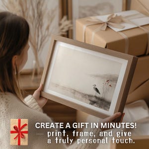 A woman holds a framed Japandi-style print featuring a heron by calm water and delicate red blossoms. She’s about to gift it to someone who cherishes quiet beauty and Japanese aesthetics. The piece’s soft ink-wash style and meditative atmosphere make it a thoughtful present for lovers of nature and tranquility.