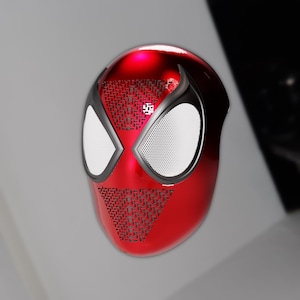 May include: A glossy red mask with a black trim and white eye lenses. The mask has a web-like pattern on the forehead and chin. The mask is a superhero-themed item.