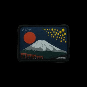 May include: A rectangular embroidered patch featuring a dark blue night sky with a large red sun, a snow-capped mountain, and a cluster of yellow floating lanterns. The text "アジア" appears in the top left, and "LEEZYART.COM" is in the bottom right.