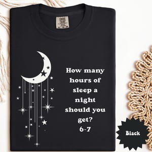 May include: Black t-shirt with a white crescent moon and stars design. The shirt features the text "How many hours of sleep a night should you get? 6-7". The shirt is a Comfort Colors brand.