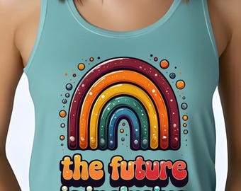 May include: A light blue tank top featuring a colorful rainbow design with the text "the future is inclusive" in a retro font. The rainbow has layers of red, orange, yellow, green, and blue.