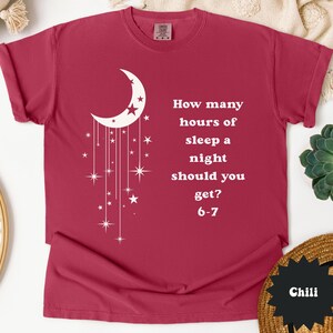 May include: A maroon t-shirt with a white crescent moon and star design. The shirt features the text: "How many hours of sleep a night should you get? 6-7."