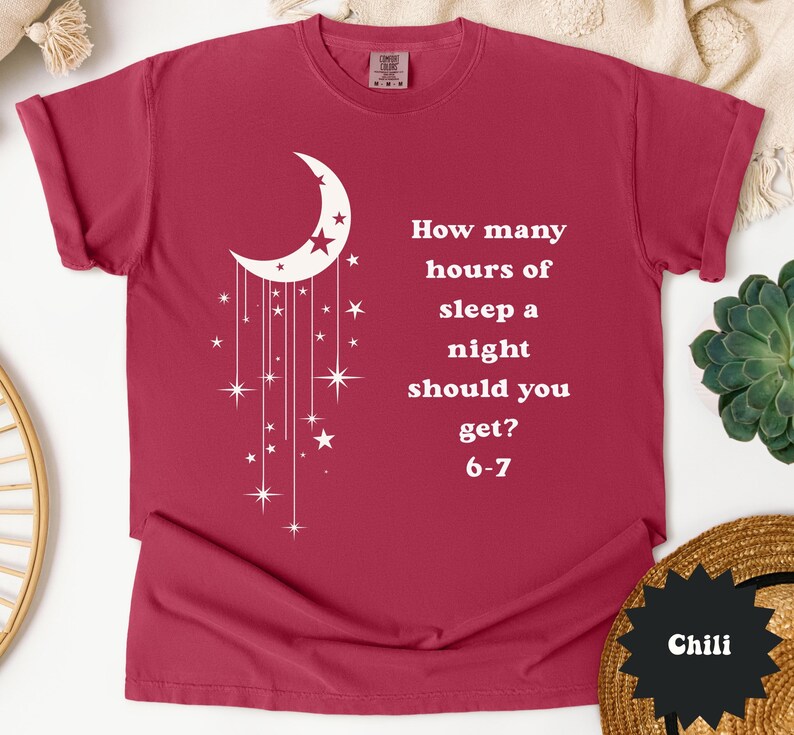 May include: A maroon t-shirt with a white crescent moon and star design. The shirt features the text: "How many hours of sleep a night should you get? 6-7."