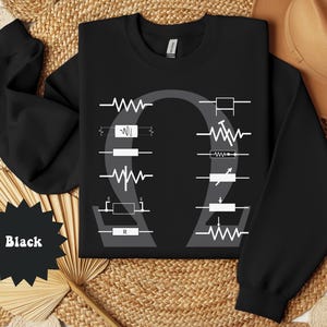 May include: Black sweatshirt with white electrical circuit symbols and the Greek letter omega. The sweatshirt has a crew neck and long sleeves. The text "Black" is in a black starburst shape.