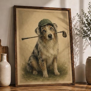 May include: A framed print of a dog wearing a green cap and holding a golf club in its mouth. The dog has blue eyes and a multi-colored coat. The artwork is set against a beige background, with a wooden frame.