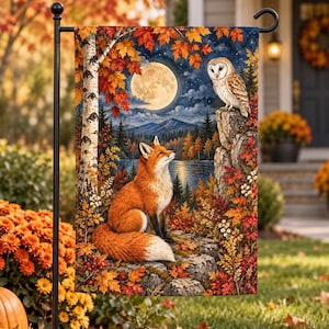 May include: A rectangular garden flag featuring a vibrant autumn scene with a red fox sitting on a rock and a barn owl perched on a stone pillar. The background displays a full moon, a lake, mountains, and birch trees with orange leaves.