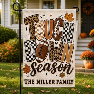 May include: A rectangular garden flag featuring the text TOUCHDOWN SEASON in a mix of leopard print, checkered, and solid brown patterns. A brown football replaces the letter O. The text THE MILLER FAMILY appears below with autumn leaves.