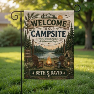 May include: A rectangular garden flag with a camping theme. The flag features the words "WELCOME TO OUR CAMPSITE" above a scenic illustration of a lake, campfire, and chairs. The names "BETH & DAVID" are at the bottom.