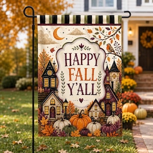 May include: A rectangular garden flag featuring a cream background with a black and white striped top border. The text HAPPY FALL Y'ALL is centered in a decorative frame, surrounded by illustrations of houses, pumpkins, and a bird.