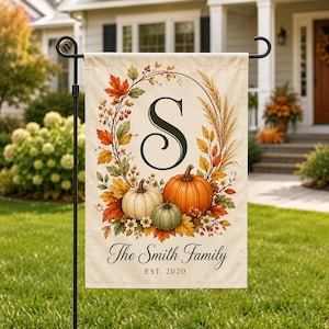 May include: A rectangular garden flag featuring a cream background with a central dark green letter S surrounded by an autumn wreath of orange, yellow, and red leaves, wheat stalks, and three pumpkins. Text reads The Smith Family EST. 2020.