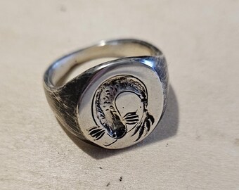 May include: A silver signet ring with a detailed engraved image of a koi fish.