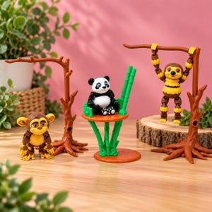 May include: A set of three animal figurines including a brown monkey, a black and white panda sitting on a green bamboo platform, and a yellow and brown sloth hanging from a brown tree branch structure, all featuring articulated joints.