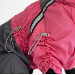 Puede incluir: Un abrigo para perros en una vibrante combinaci&oacute;n de rosa y gris. El abrigo cuenta con un cierre de cord&oacute;n y una franja reflectante para mayor visibilidad. El dise&ntilde;o incluye una capucha y est&aacute; hecho de un material resistente al agua.