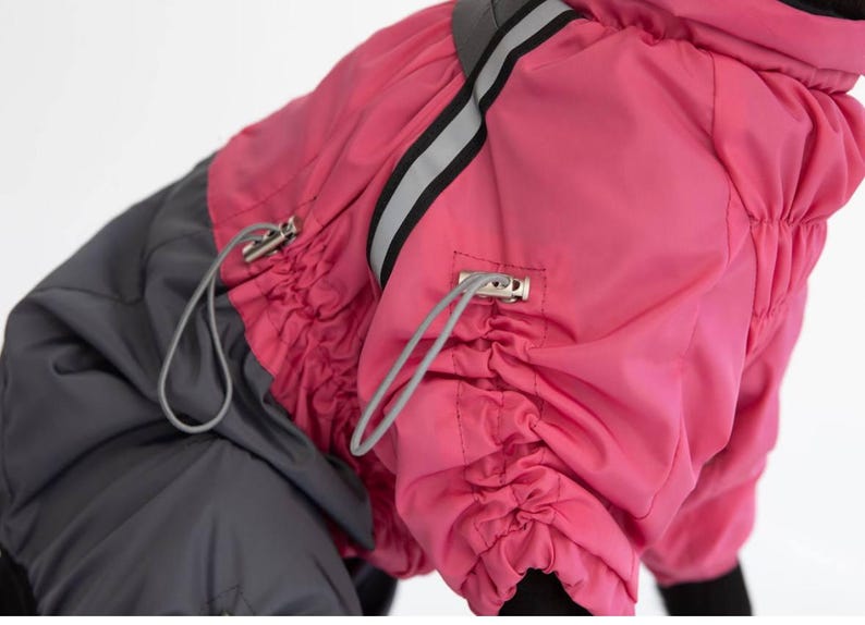 Puede incluir: Un abrigo para perros en una vibrante combinaci&oacute;n de rosa y gris. El abrigo cuenta con un cierre de cord&oacute;n y una franja reflectante para mayor visibilidad. El dise&ntilde;o incluye una capucha y est&aacute; hecho de un material resistente al agua.