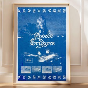 May include: A blue and white rectangular poster featuring a portrait of Phoebe Bridgers with the text Phoebe Bridgers and The Reunion Tour. The design includes a border of small symbols and four small rectangular images at the bottom.
