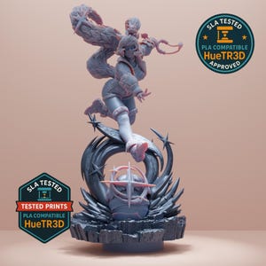 May include: A detailed 3D-printed figurine of a character in a dynamic pose, with a flowing, stylized element extending above. The figure is predominantly gray, with accents of pink and white. The base features a complex design with star-like elements and a spherical object. The image includes two "SLA Tested" badges.