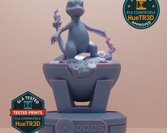 May include: A light blue 3D-printed figurine of a lizard-like creature, posed atop a stylized base. The base is a combination of a sphere and a rectangular platform. The figurine has flames on its tail and is labeled with the number "0005".