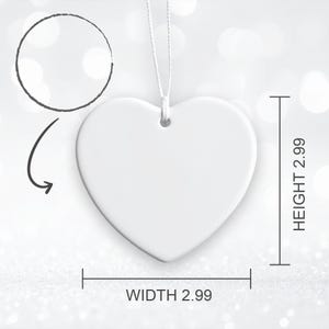 Op de afbeelding: Een wit hartvormig ornament met een glad oppervlak en een klein gaatje aan de bovenkant om op te hangen. Er is een wit touwtje bevestigd. De afbeelding bevat maataanduidingen met een hoogte van 2,99 cm en een breedte van 2,99 cm.