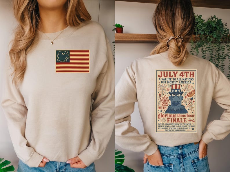 Puede incluir: Sudadera beige con un dise&ntilde;o patri&oacute;tico. La parte delantera presenta una bandera estadounidense con una cabeza de &aacute;guila en el campo azul. La parte trasera muestra un p&oacute;ster de estilo vintage con el texto "July 4th" y un &aacute;guila de dibujos animados.
