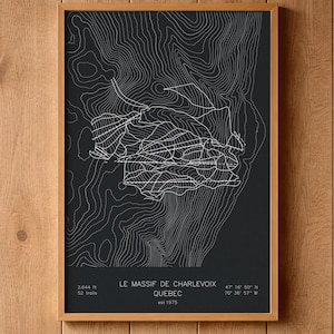 May include: A framed topographic map print of Le Massif de Charlevoix, Quebec, featuring white contour lines on a dark gray background. The text includes the location name, 2,644 ft elevation, 52 trails, coordinates, and est. 1975.