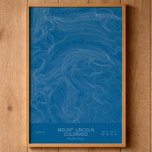 May include: A rectangular framed print featuring a blue topographic map of Mount Lincoln, Colorado. The map displays white contour lines against a solid blue background. Text at the bottom reads Mount Lincoln, Colorado, 14,293 ft, 39 21 05 N, 106 06 42 W.