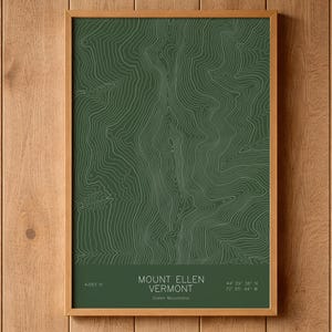 May include: A framed topographic map print of Mount Ellen in Vermont, featuring white contour lines on a dark green background. The text reads Mount Ellen, Vermont, Green Mountains, 4,083 ft, and the coordinates 44° 09' 36" N, 72° 55' 44" W.
