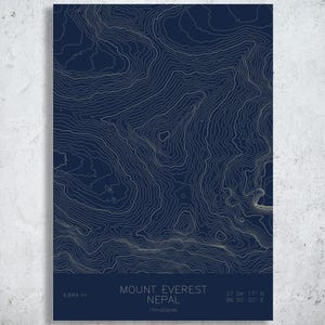 May include: A navy blue print of Mount Everest in Nepal, featuring topographic lines in a light beige color. The print includes the mountain's elevation, coordinates, and the text "Mount Everest Nepal Himalayas."