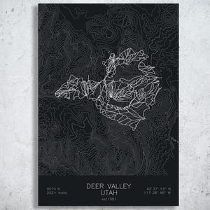 May include: A black rectangular print featuring white topographic contour lines of Deer Valley, Utah. The text reads DEER VALLEY UTAH, est 1981, 9570 ft, 202+ trails, and coordinates 40 37 53 N 111 28 46 W. The design includes white trail map lines.