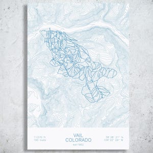 May include: A vertical print featuring a blue topographic map of Vail, Colorado, with ski trail outlines. The bottom white section displays the text VAIL COLORADO, est 1962, 11,570 ft, 195 trails, and coordinates 39 38 21 N 106 22 26 W.