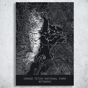 May include: A black and white topographic map print of Grand Teton National Park in Wyoming. The map features detailed contour lines and the park's outline. The text "GRAND TETON NATIONAL PARK WYOMING" is printed at the bottom.