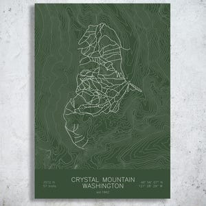 May include: A dark green poster featuring a white topographic map of Crystal Mountain, Washington. The design includes white contour lines, trail paths, and text stating Crystal Mountain Washington, 7012 ft, 57 trails, and est 1962.