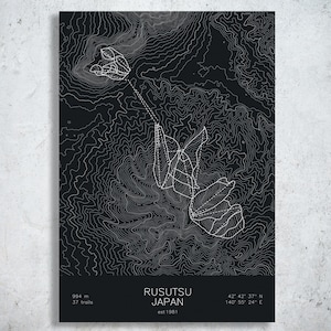 May include: A black poster featuring white topographic contour lines of Rusutsu, Japan. The design includes white dashed lines representing ski trails, with text at the bottom reading Rusutsu Japan, est 1981, 994 m, 37 trails, and coordinates 42 42 37 N 140 55 24 E.