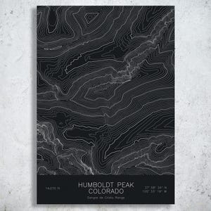 May include: A rectangular wall art print featuring a black background with white topographic contour lines of Humboldt Peak, Colorado. The bottom section includes the text Humboldt Peak Colorado, 14,070 ft, and coordinates 37 58 34 N 105 33 19 W.