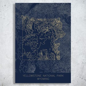 May include: A navy blue print of Yellowstone National Park in Wyoming. The map features a detailed topographic design in a gold color, with the park's outline clearly visible. The text "YELLOWSTONE NATIONAL PARK WYOMING" is printed at the bottom.