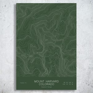 May include: A rectangular print featuring a dark green topographic map of Mount Harvard in the Sawatch Range, Colorado. The text reads: MOUNT HARVARD COLORADO, Sawatch Range, 14,421 ft, and the coordinates 38 55 28 N 106 19 15 W.
