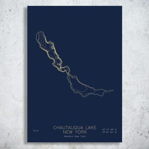 May include: A dark blue rectangular print featuring a gold-colored topographic map of Chautauqua Lake, New York. The text reads Chautauqua Lake, New York, Western New York, 75 ft, and the coordinates 42 10 48 N 79 24 00 W in a clean sans-serif font.