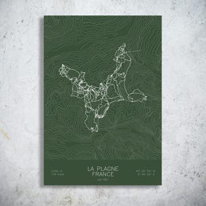 May include: A dark green topographic map print of La Plagne, France, featuring white contour lines and trail paths. The text reads: LA PLAGNE FRANCE, est 1961, 3,250 m, 134 trails, and the coordinates 45° 29' 50" N, 6° 46' 22" E.