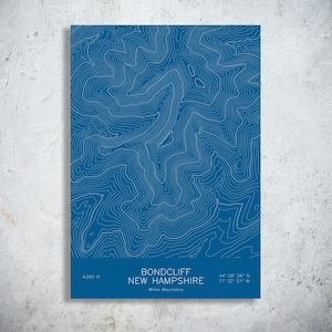 May include: A rectangular print featuring a blue background with white topographic contour lines representing Bondcliff in the White Mountains of New Hampshire. The text reads Bondcliff, New Hampshire, White Mountains, 4,265 ft, 44 08 26 N, 71 32 27 W.