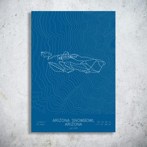 May include: A blue rectangular print featuring white topographic contour lines and a stylized map of the Arizona Snowbowl ski area. The text reads ARIZONA SNOWBOWL ARIZONA, est 1938, 11,500 ft, 55 trails, and coordinates 35 19 34 N 111 41 08 W.