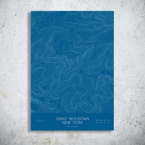 May include: A rectangular wall art print featuring a blue background with white topographic contour lines. The text reads GIANT MOUNTAIN NEW YORK, Adirondacks, 4,627 ft, and the coordinates 44 09 40 N, 73 43 13 W at the bottom.