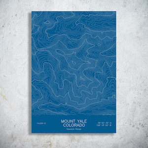 May include: A rectangular print featuring a blue background with white topographic contour lines representing Mount Yale, Colorado. The text reads Mount Yale Colorado, Sawatch Range, 14,200 ft, and the coordinates 38 50 39 N 106 18 50 W.