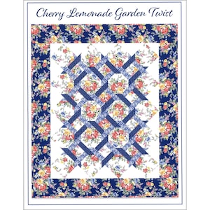 May include: A quilt with a floral pattern and the text "Cherry Lemonade Garden Twist". The quilt features a white center with a lattice design of blue and white polka dots. The border is a dark blue floral print.